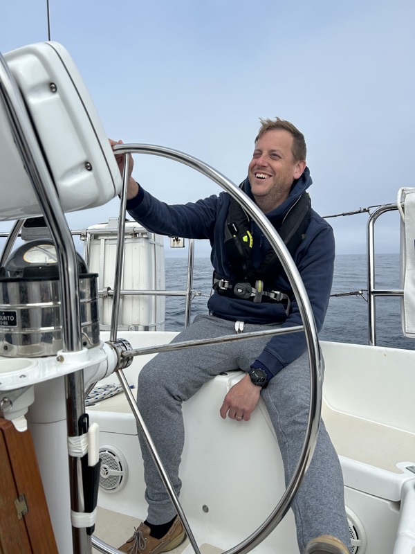 Ian Bezanson at the helm of a sailboat